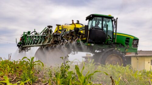 Traktor beim Düngen auf einem Feld